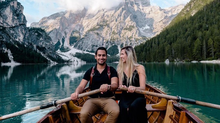Mark and Judith enjoying boating with mountains in the background.