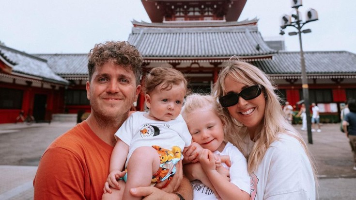 Stephen and Jess posing in front of the camera with children in front o