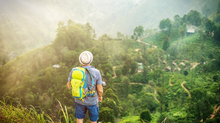 A tourist taking in the beauty of sunrise in Adam's Peak.