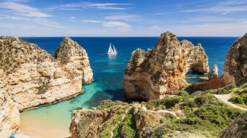 Indulge in endless summer fun as you explore the stunning coastal regions, known for their perfect Mediterranean climate and breathtaking beauty. Scenic landscape and beach on Algarve coast, Portugal.