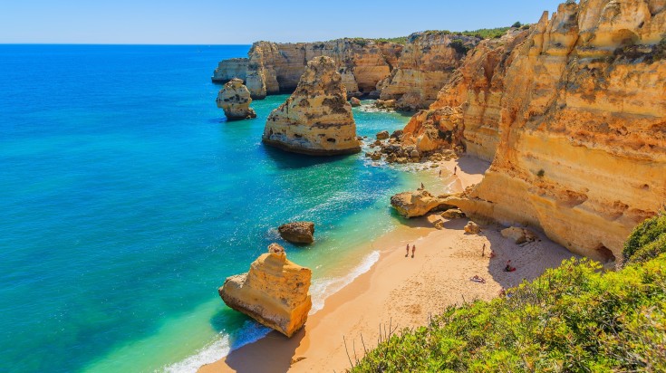 View of beautiful Praia de Marinha with crystal clear water on a clear day.