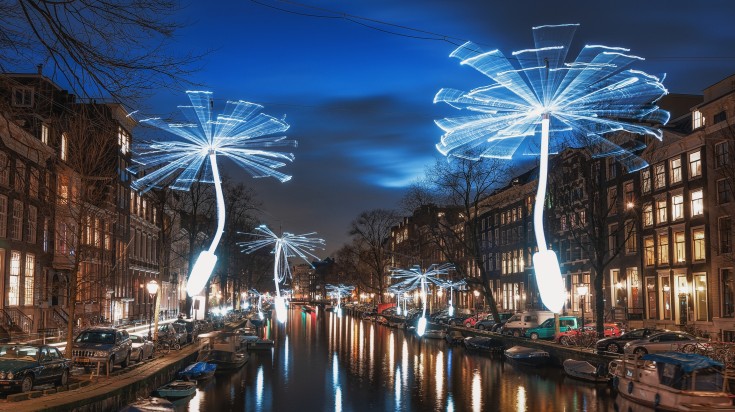 Wind propellers lit with white lights in Amsterdam at night.