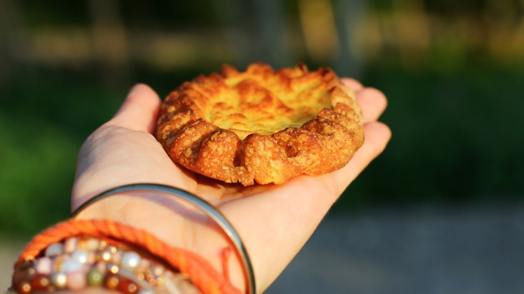 An extended hand showing Karelian Pie with potato filling.