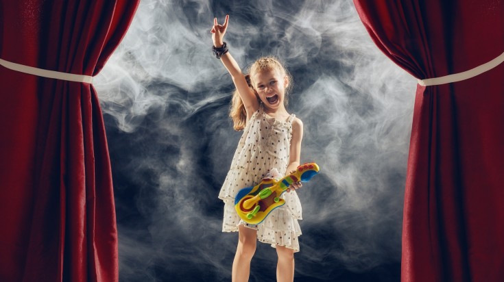 A little girl playing guitar in the stage in Iguaza concert.