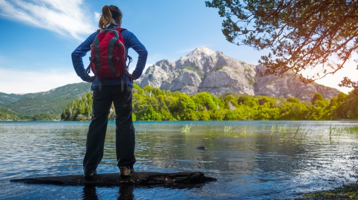 Woman hiker enjoys view of the lake and mountains. Bariloche, Argentina