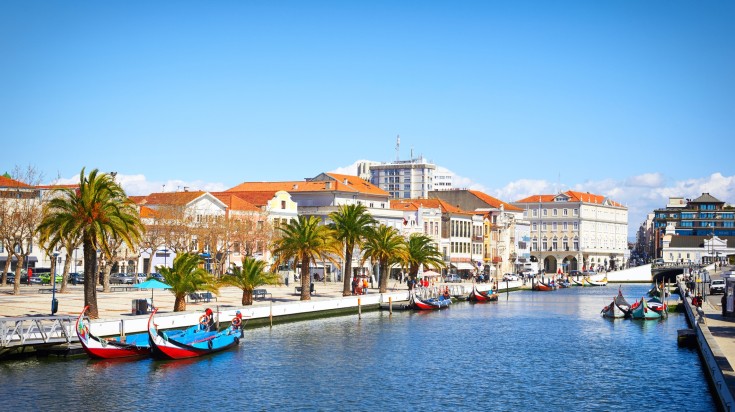 Traditional boats on the canal in Aveiro during bright day in Portugal.