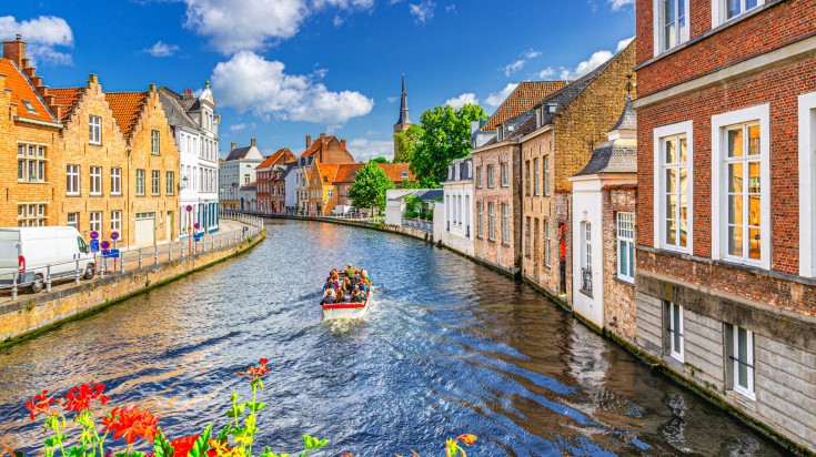 Tourists on a river cruise on a boat on a sunny day in Belgium in July.