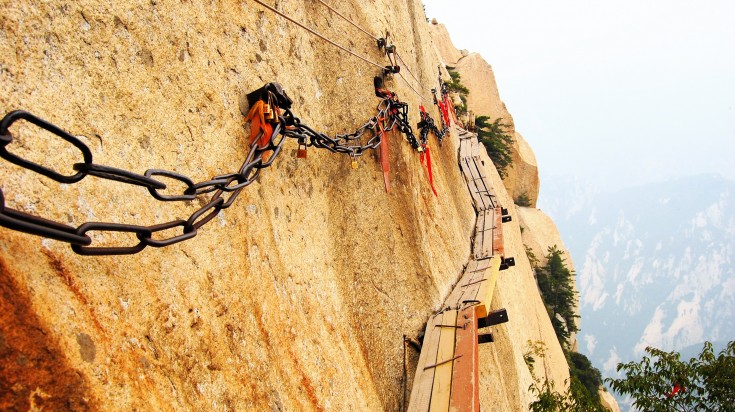 Planks and chains nailed to the side of a rocky mountain