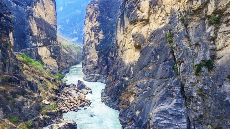 River flowing in between two rocky cliffs at Tiger Leaping Gorge.