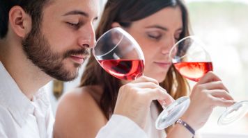 A man and a woman tasting red wine