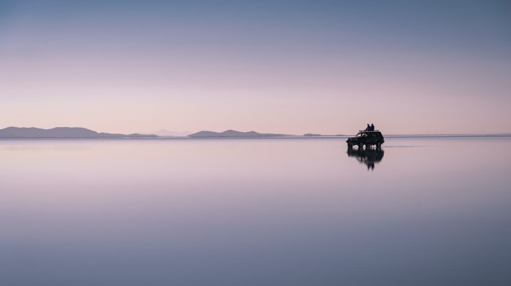 Tourists sitting on a 4x4 vehicle at Uyuni Salt Flats in Bolivia in Novembe