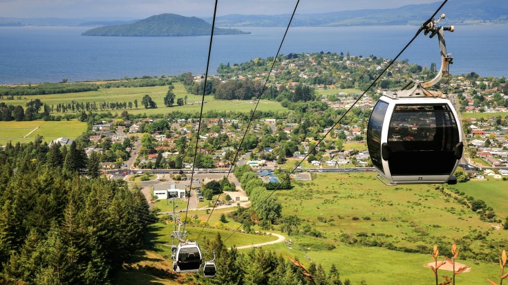 Cable cars, a town, hills, and lakes as seen in Rotorua.