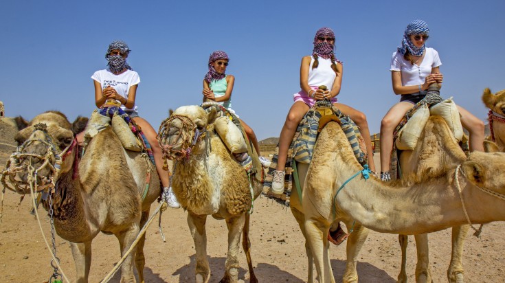 You can get on a camel rides like these tourists while touring Egypt.