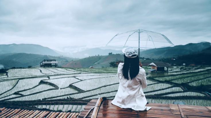 A girl holding an umbrella during rain in Chiang Mai in Thailand.