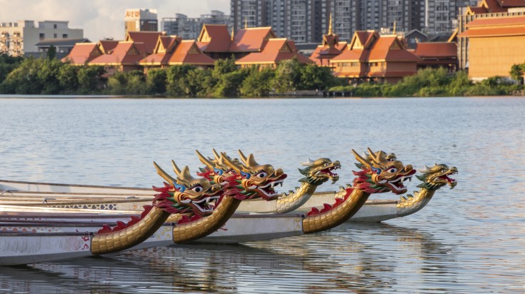 Boats in China in June during sunset with dragons carved on them.