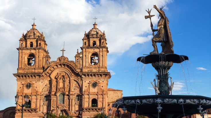 Statue of Pachacuti and Catholic church are major sights in Cusco.