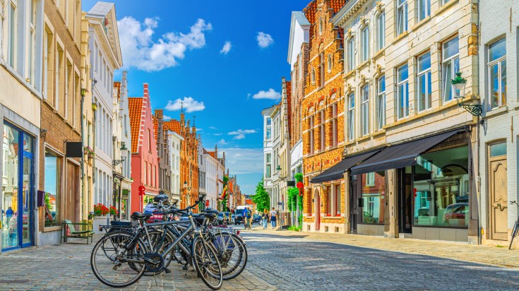 Cycles parked amidst colorful buildings of Bruges.