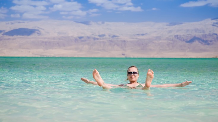 A young girl floating of the Dead Sea in Jordan.