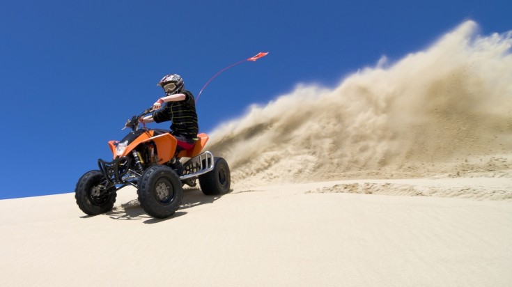 Ride through the sand on a quad bike in a desert safari in Dubai