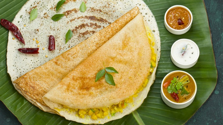 Dosa served in a traditional South Indian banana leaf plating.