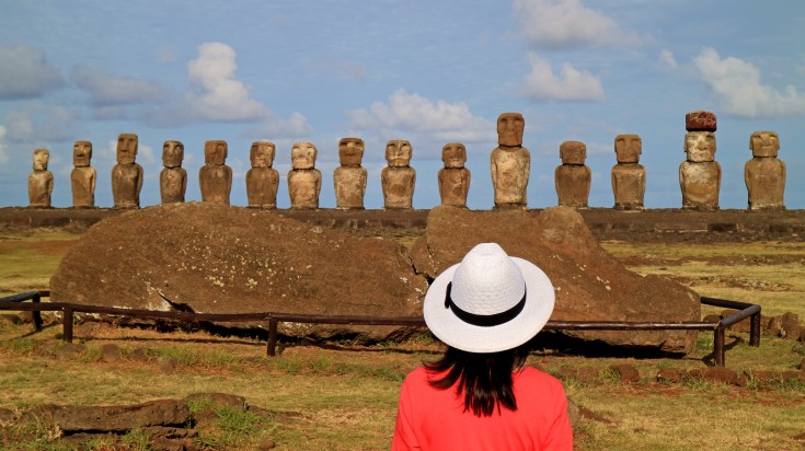 A female tourist observing the Moai statues in Easter Island.