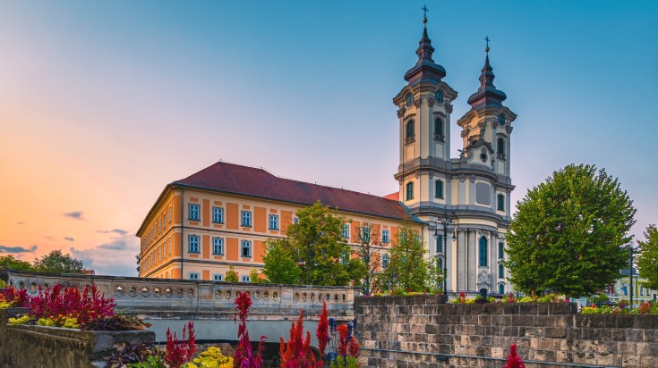 A view of a Catholic church from the waterfront at dawn in Eger.