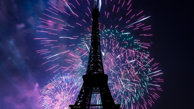 Eiffel Tower and fireworks in the background at night.