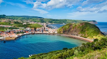 A city on a lush island surrounded by turquoise blue ocean