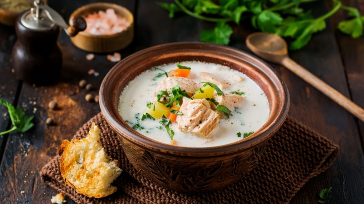 Warm Finnish creamy soup with salmon and vegetables