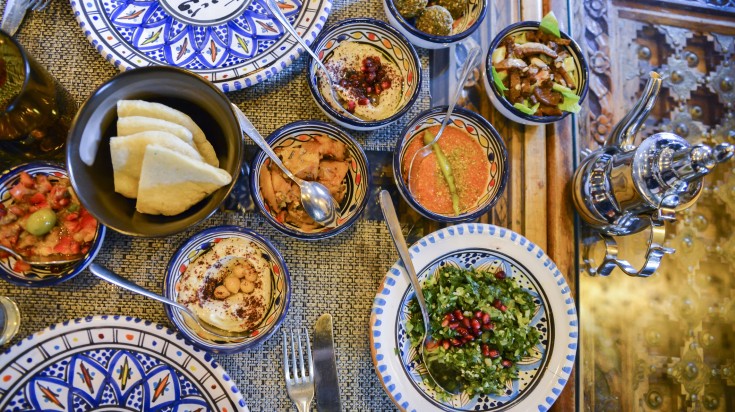 Jordan dishes and assorted breads, meats, rice in the table.