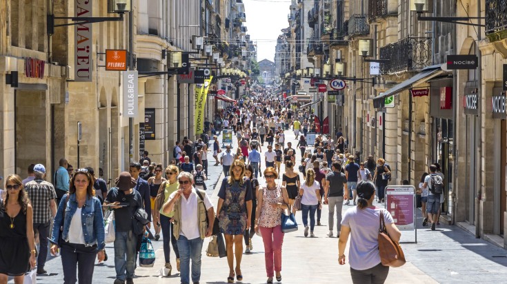 People walk on Rue Sainte Catherine while touring France.