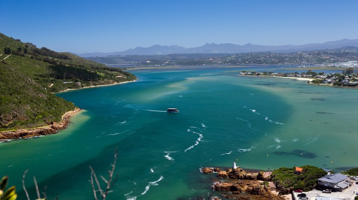 A boat cruising on the water in Knysna Lagoon in South Africa.