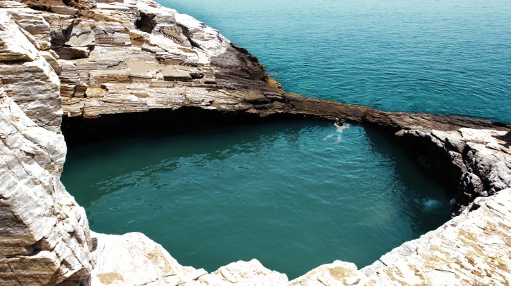 Man swimming alone in natural pool Giola in Greece