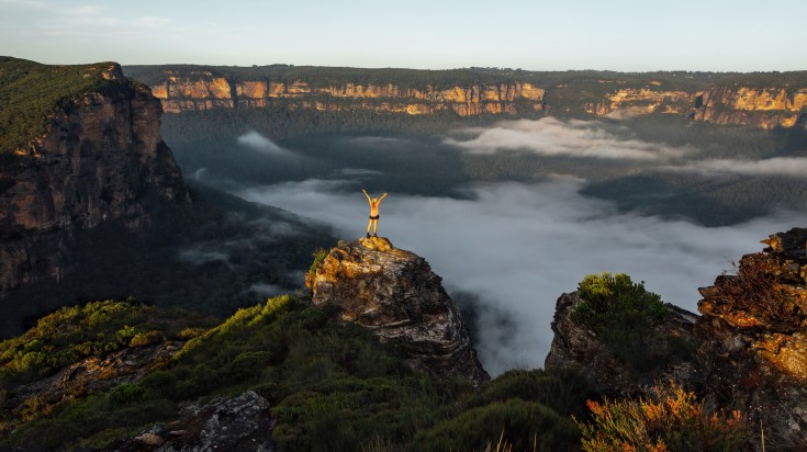 A woman with open arms watching the view at the Blue Mountains.