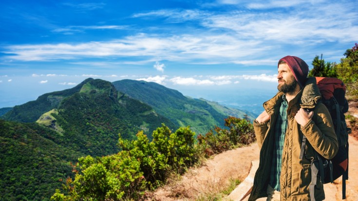 A hiker in the World's End in Horton Plains National Park during a cloudy d