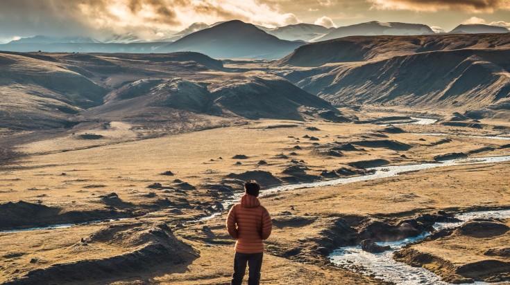 Hiker admiring the view of Icelandic Highlands during summer.