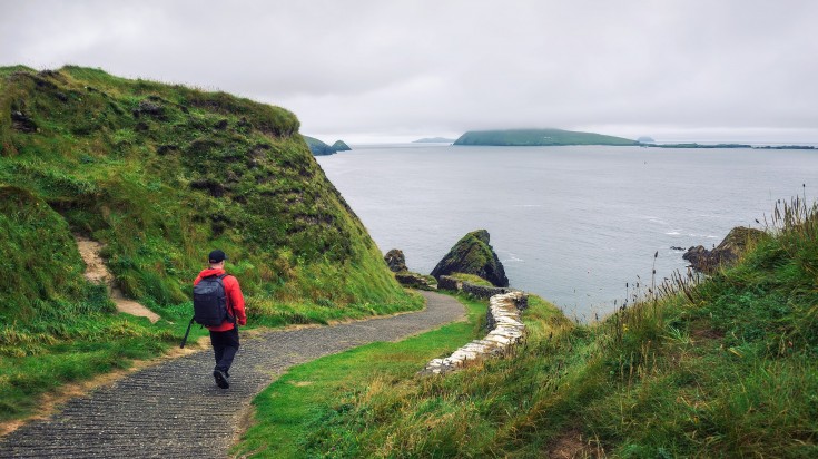 Young man hikes along a pathway while touring Ireland.