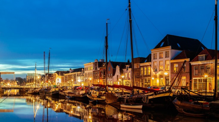 Evening view of a Dutch canal with sailing boats in the city center of Zwol