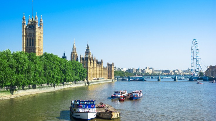 Parliament overlooks the Thames, boats below in England in February.