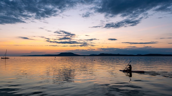 A person kayaking during sunset at Lake Balaton.