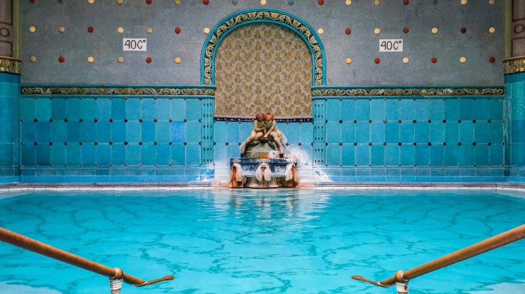 A spa in Hungary with blue tiles and fountain in the middle.