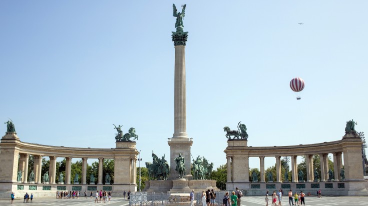 Tourists walking around Millennium Monument in Hungary in March.