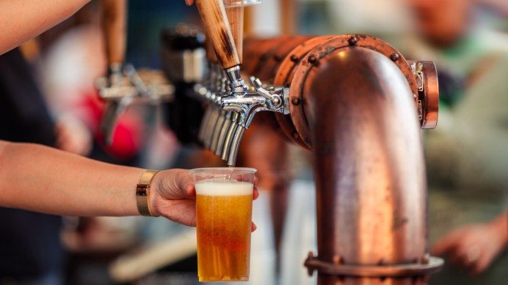 A person using a tap to fill beer glass in Hungary in May.