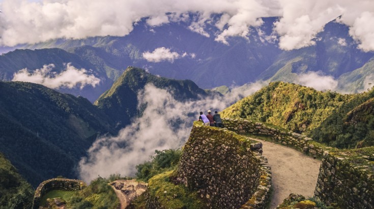 Hikers looking a the view of mountains and clouds from the Inca trail.