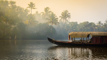 Taste the joys of staying in one of Kerela's famous houseboats A traditional house boat is anchored on the shores of a fishing lake in Ker