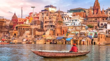 Ancient Varanasi city architecture and Ganges river ghat at sunset with vie