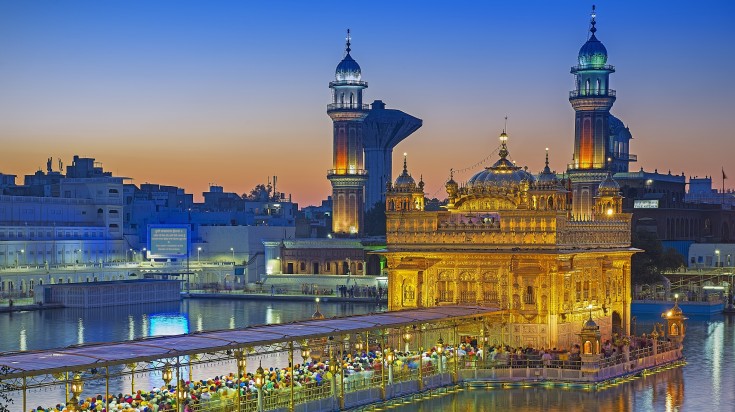 The Golden Temple sits on a rectangular platform, surrounded by a pool of wa