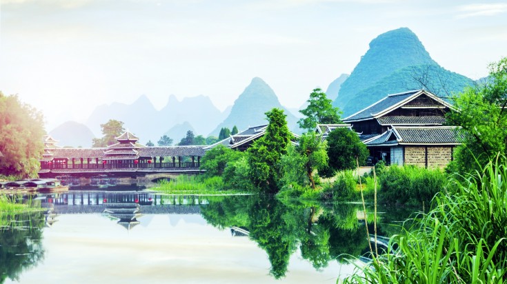 A view of a house in Xinping with hills behind it