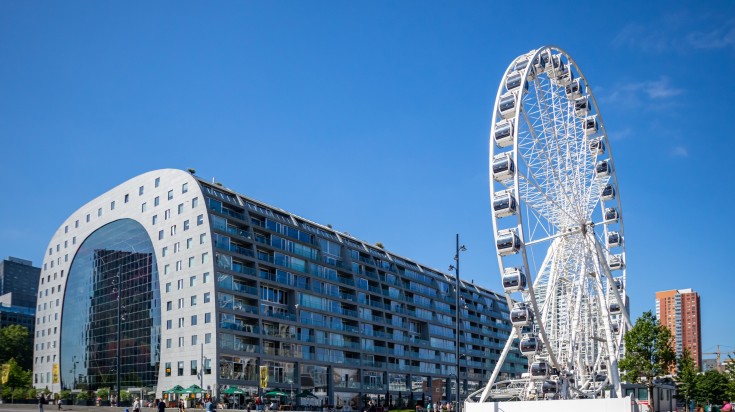 Markthal and the ferris wheel on a sunny day in Rotterdam.