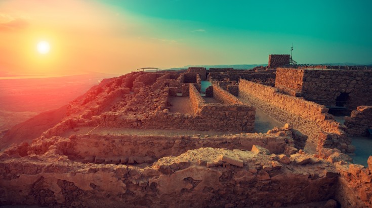 Savor the splendor of Masada fortress while basking in the glory of the sunrise over this ancient land. Beautiful sunrise over the Masada fortress in Judaean Desert in Israel.